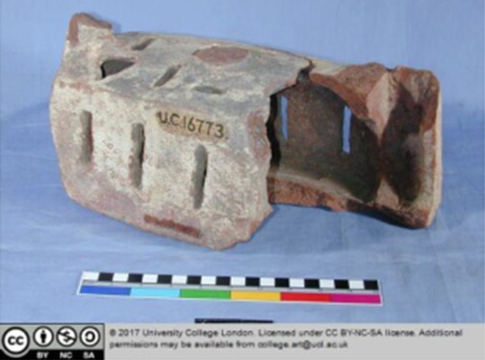 A pottery rectangular 'cage' with air slits, partially broken, about the size of a large brick.