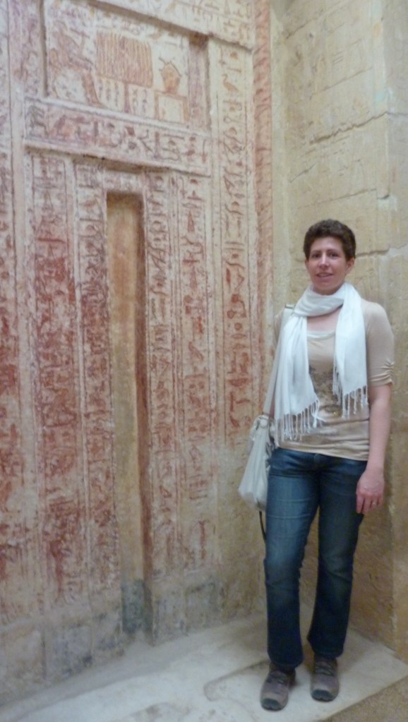 Hannah standing beside a large red false door in a Giza mastaba