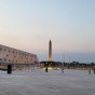 The photo shows an open court with a hanging obelisk in the centre, flanked by colonnades leading to the entrance of the Grand Egyptian Museum